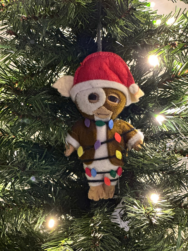 Brown felt ornament with a red Santa hat and colorful lights hanging on a Christmas tree.