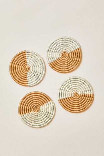 Four round woven coasters with a two-tone design on a beige background