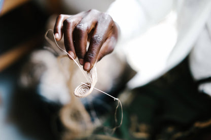Close-up of a person's hand holding a piece of string or thread.