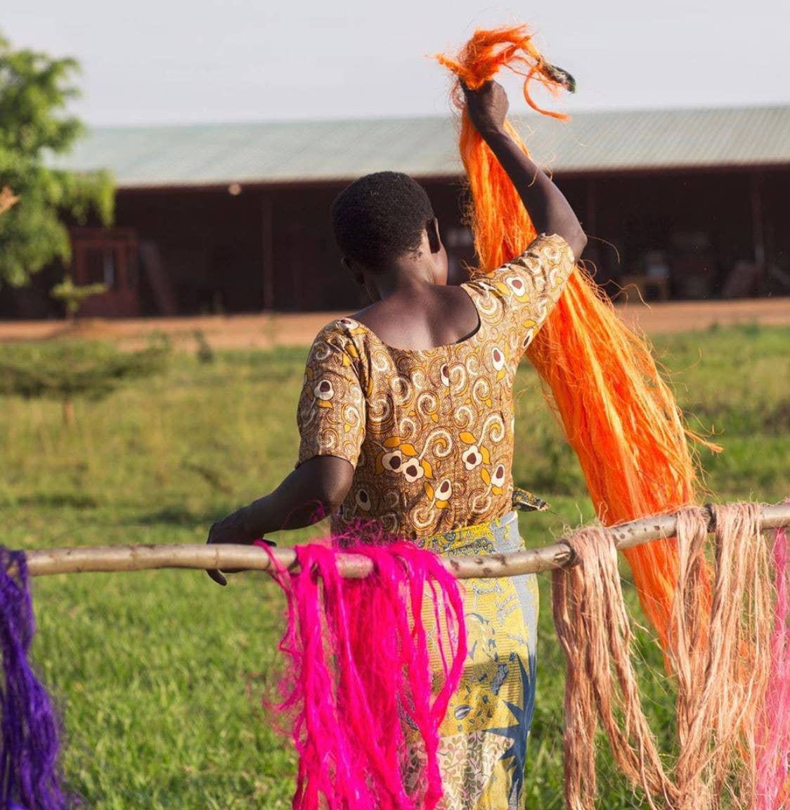 Woman hanging colorful yarn on a line outdoors
