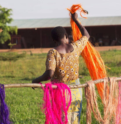 Woman hanging colorful yarn on a line outdoors