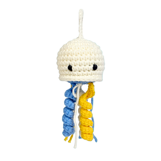 Crocheted jellyfish toy with blue and yellow tentacles on a teal underwater background