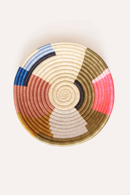 Colorful woven basket with concentric circle pattern on a white background