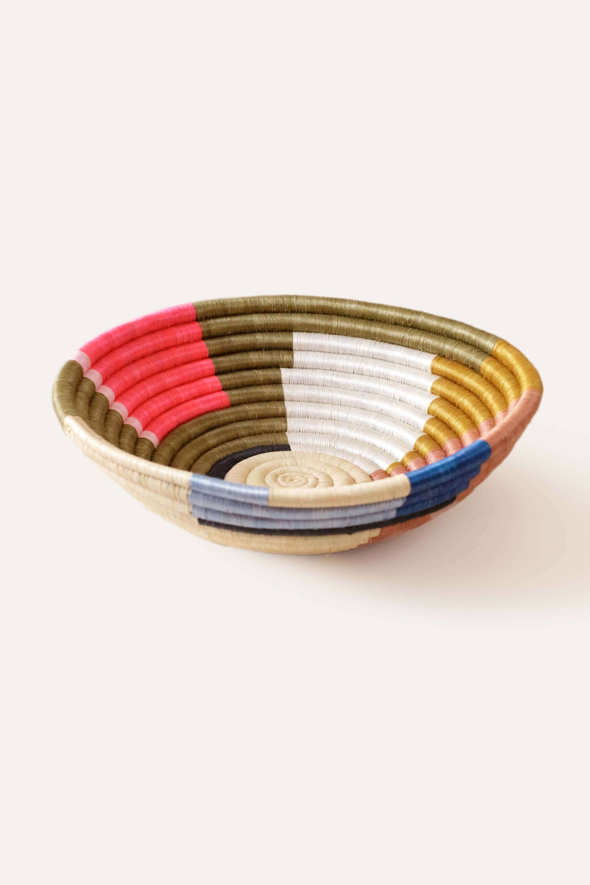 Woven bowl with multicolored stripes on a white background
