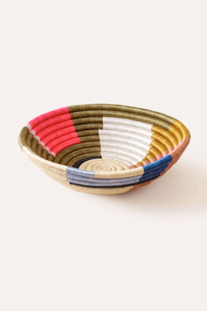 Woven bowl with multicolored stripes on a white background