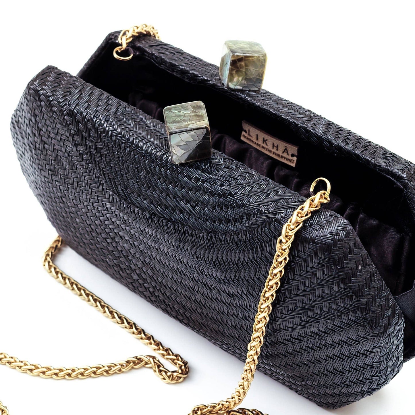 Black woven clutch bag with gold chain strap on a white background