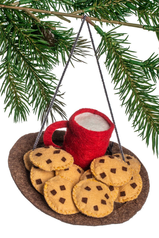 Felt ornament of a red mug with cookies hanging from a tree branch