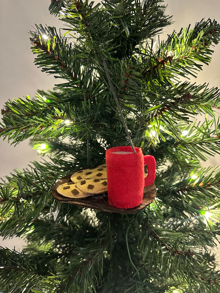 Christmas tree ornament with red mug and cookie on a wooden plate