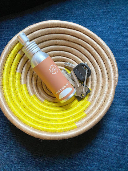 Coiled basket with a bottle and keys on a blue background