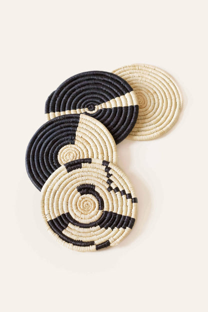 Set of black and beige woven coasters on a light background