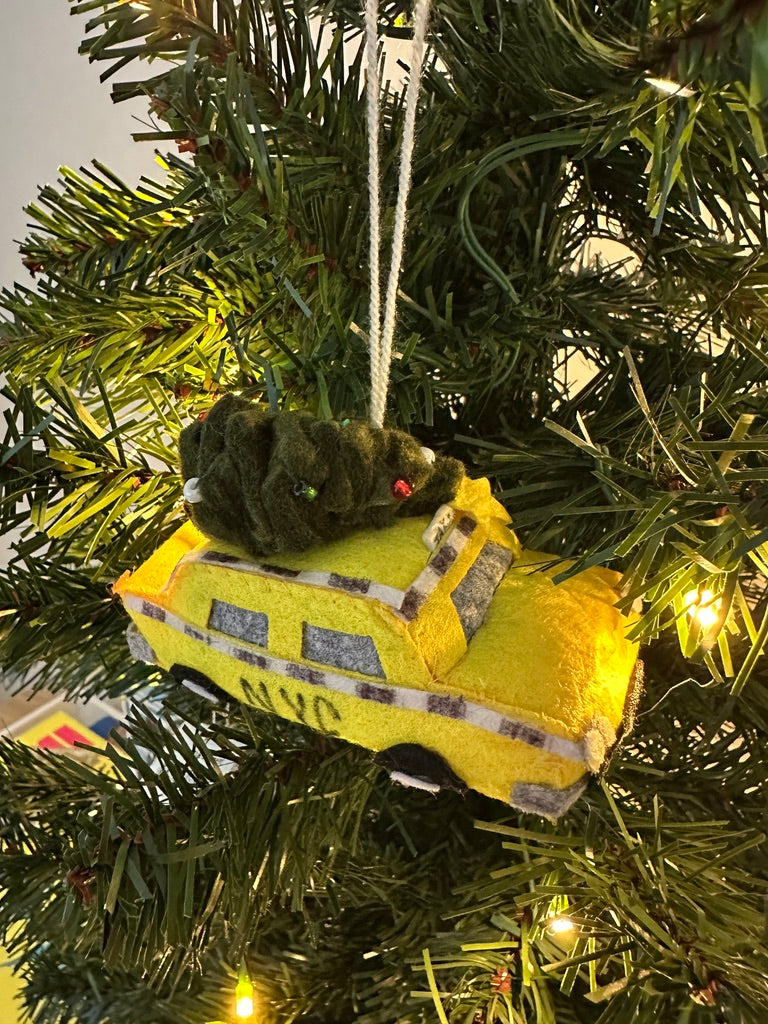 Yellow ambulance plush toy hanging on a Christmas tree