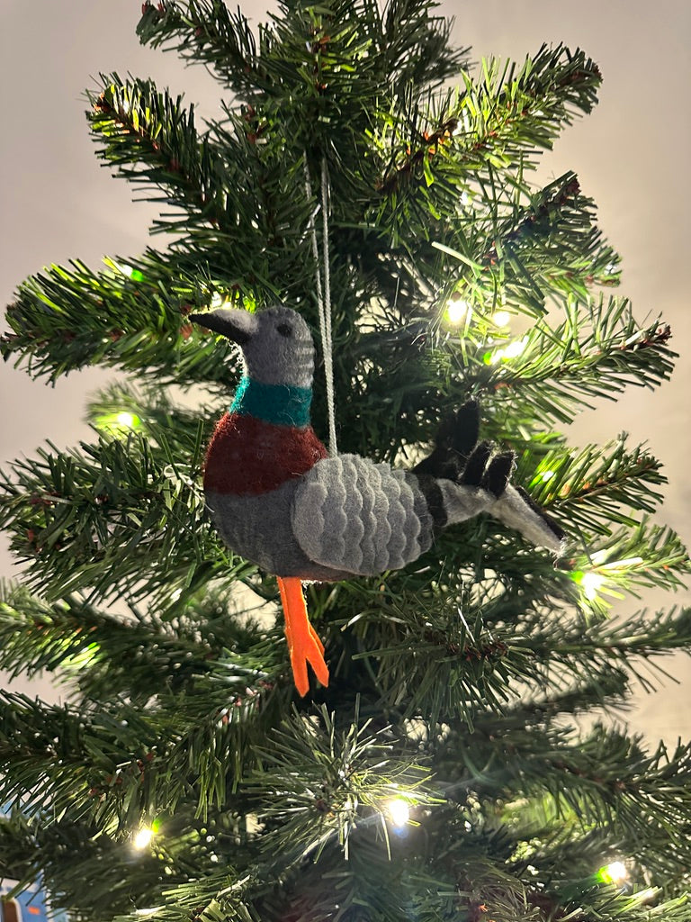 Decorative bird ornament on a lit Christmas tree