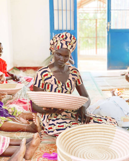 Woman working with woven baskets in a room with blue doors.