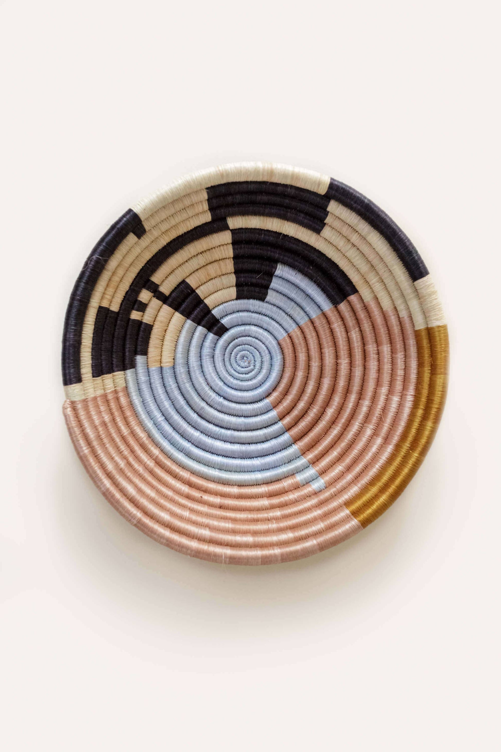 Woven basket with concentric circle pattern on a white background