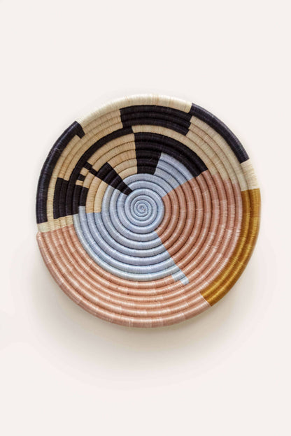 Woven basket with concentric circle pattern on a white background