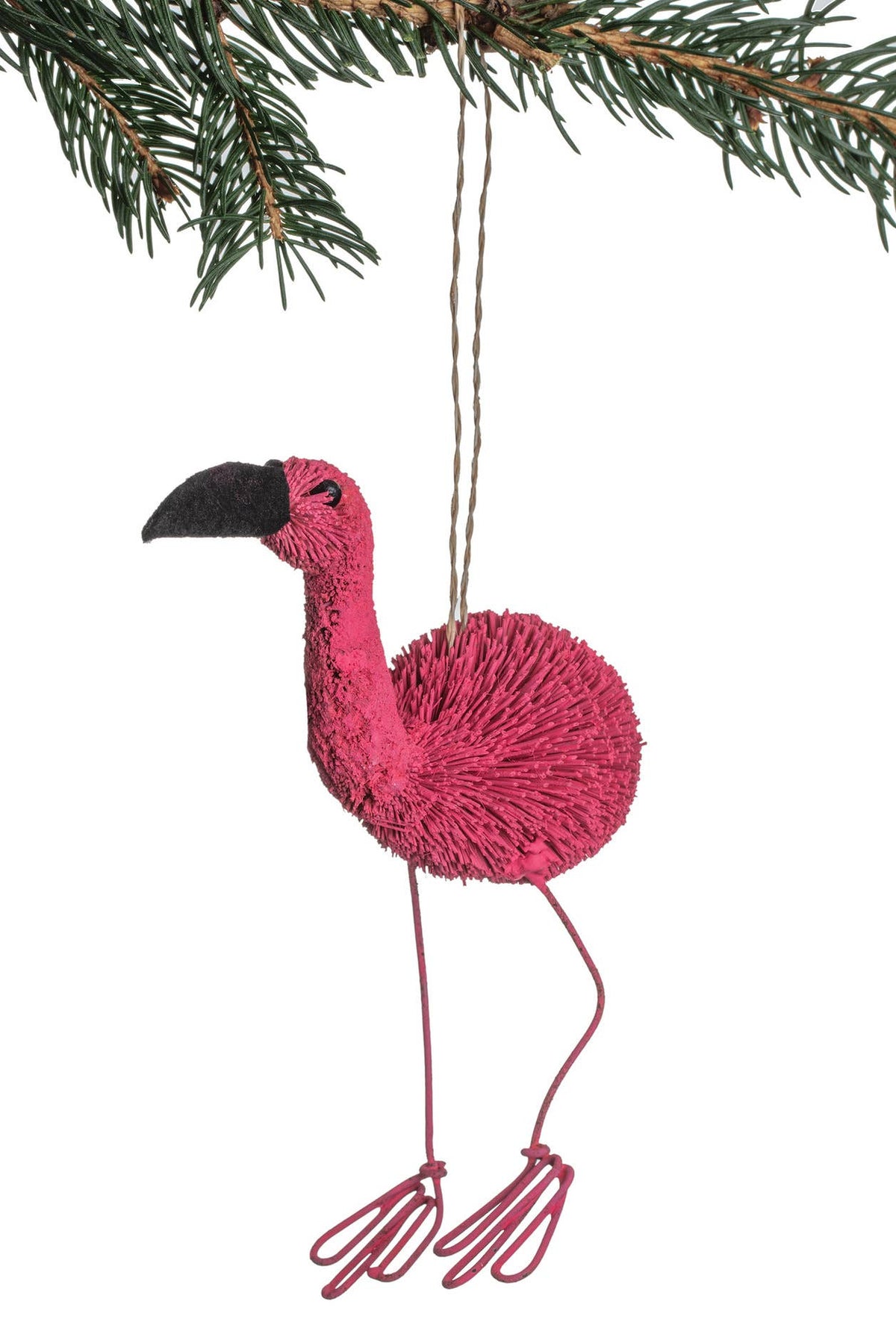 Pink flamingo ornament hanging from a branch with green leaves.