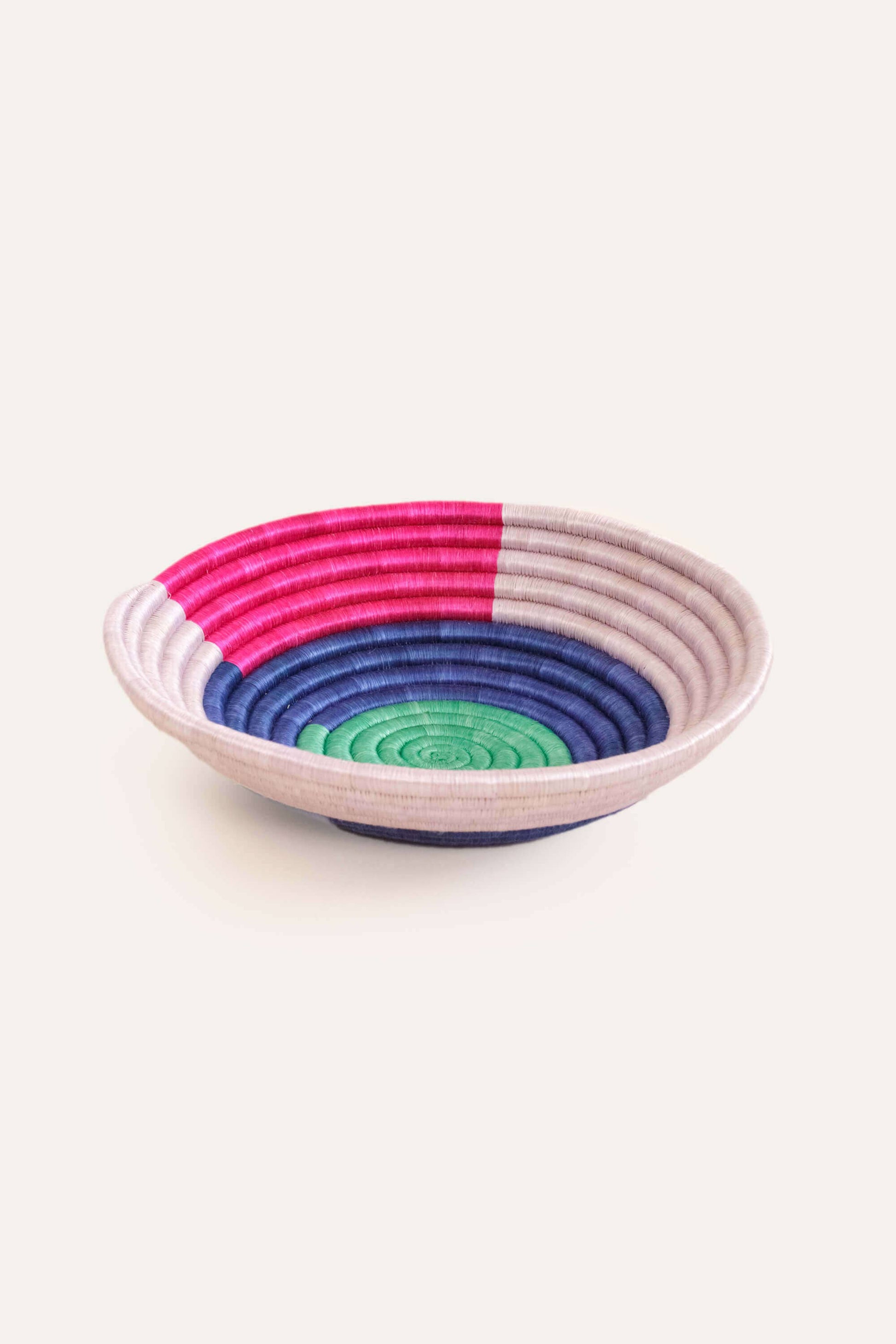 Woven bowl with concentric colorful rings on a white background