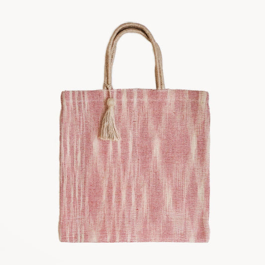 Red and white striped tote bag with a tassel on a white background