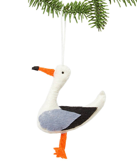 Decorative seagull ornament hanging from a branch on a white background