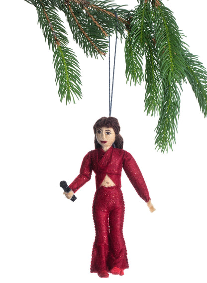 Decorative ornament of a person in a red outfit hanging from a Christmas tree branch.