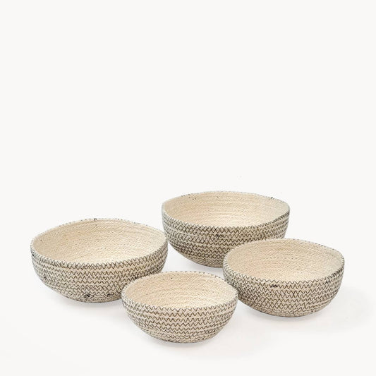 Set of four woven baskets on a white background