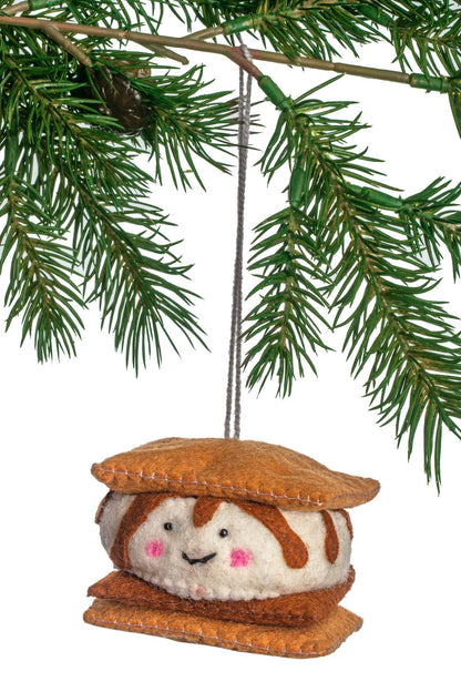 Felted ornament shaped like a marshmallow with a face, hanging from a tree branch.