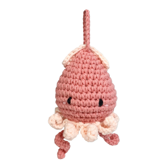 Crocheted pink octopus toy with a blue underwater background