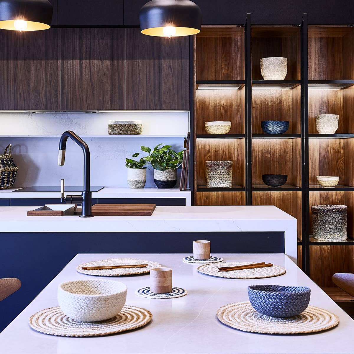 Modern kitchen with wooden shelves, white countertops, and decorative bowls.