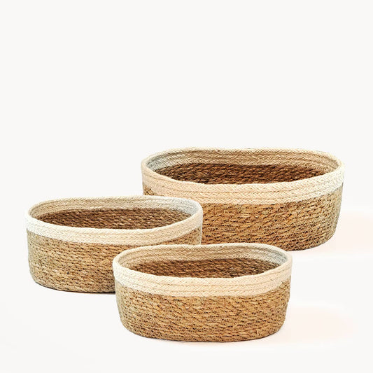 Set of three woven baskets with a natural color scheme on a white background