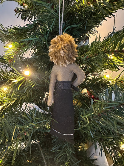 Decorative ornament hanging on a Christmas tree. Ornament is a female singer in a black dress holding a microphone.