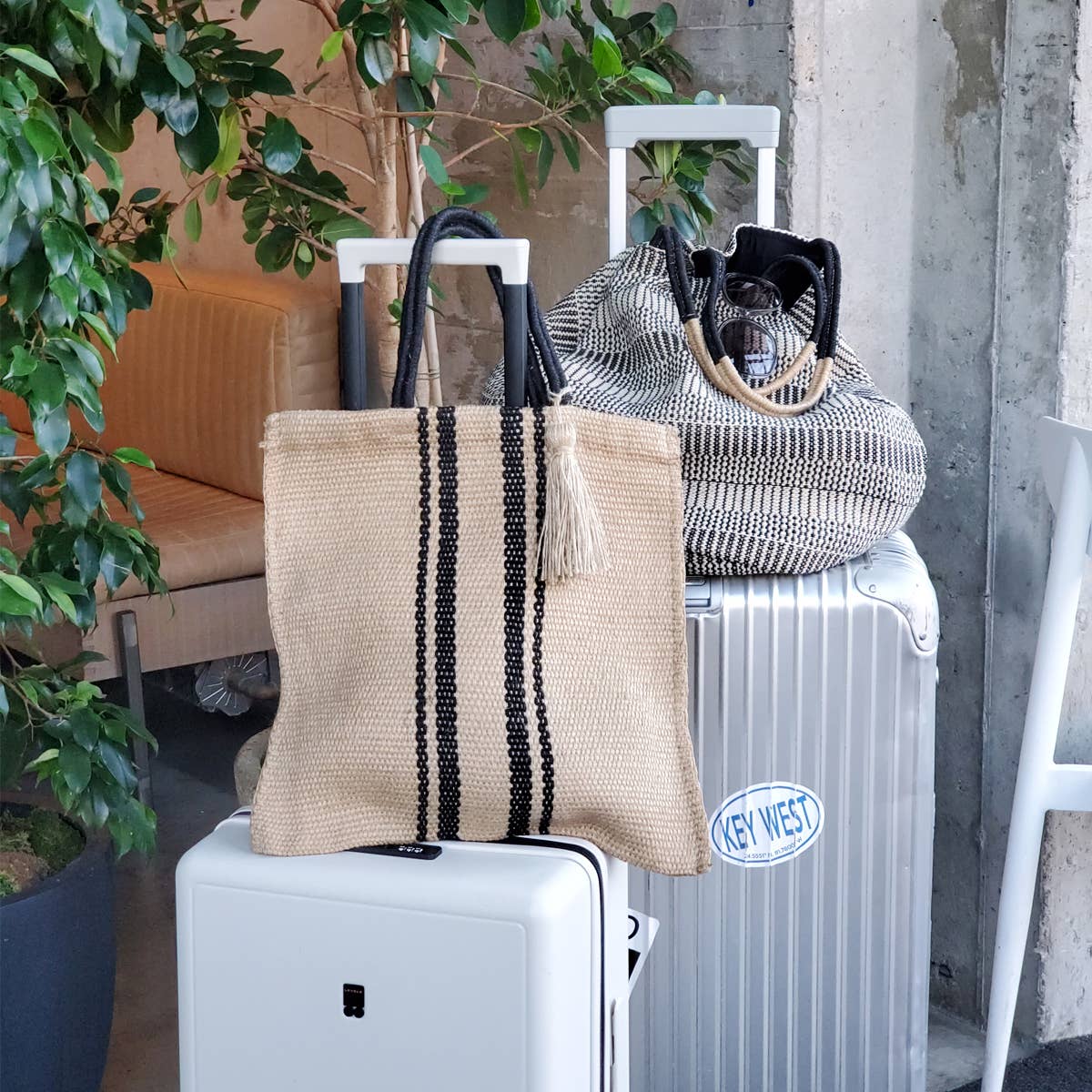 Two handbags on a suitcase with a plant and radiator in the background