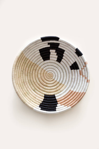 Woven basket with concentric circle pattern on a white background