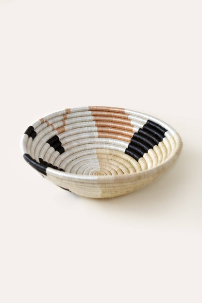 Woven bowl with black, brown, and beige pattern on a white background