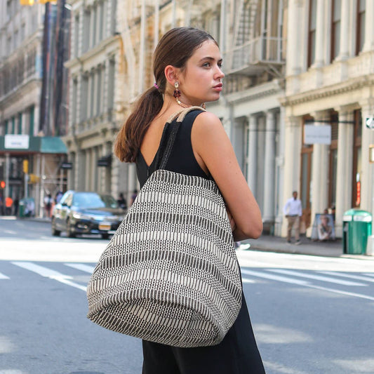 Woman carrying a large patterned bag on a city street