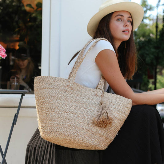 Woman holding a woven bag outdoors with blurred background