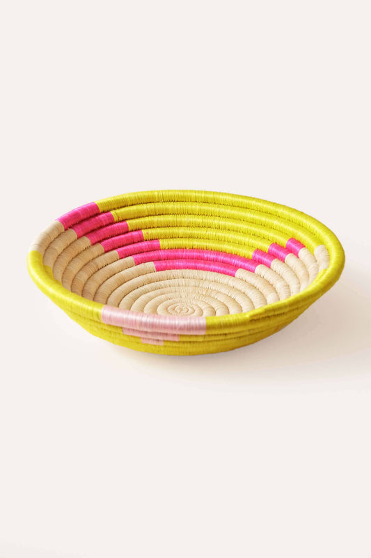 Woven basket with pink and yellow pattern on a white background